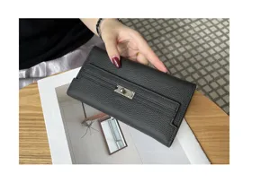 Close-up detail of black leather long wallet with metallic turn-lock closure and texture.