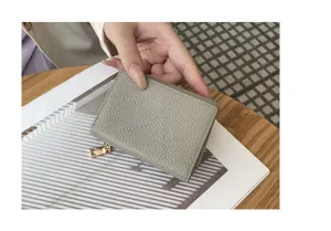 Close-up detail of women trifold mini leather wallet in gray color with compact coin pocket.
