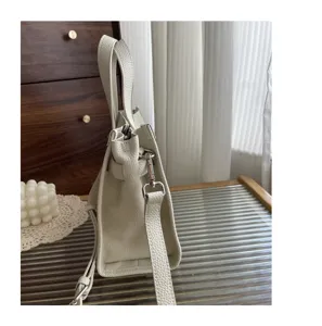 Vue de détail du profil latéral d'un sac à main en cuir véritable avec accessoires métal.