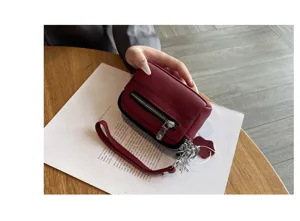 Genuine leather mini coin purse wristlet handbag featuring double zippers and strap detail.