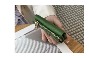 Green genuine leather short triple-fold wallet detail view featuring compact shape and coin pocket.