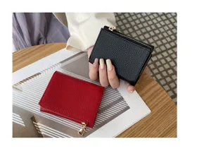 Close-up compact trifold mini wallet showing fine texture and sleek zipper pocket detail.