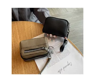 Detail view of mini genuine leather coin purse with double zippers, compact and portable style.