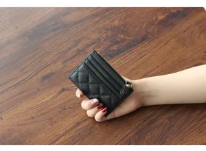 Detailed view of the black quilted leather card holder, showing fine stitching and smooth zipper.