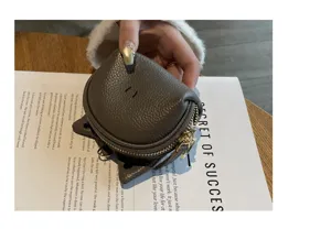 Detailed close-up of genuine leather coin purse with cute animal ears and secure zip closure.