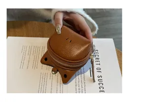 Close-up detail shot of cute brown leather coin purse, compact design with metal zipper.