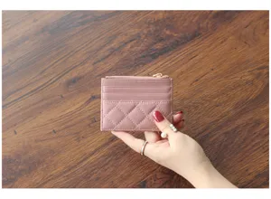 Close-up detail view of the pink quilted leather card holder showing zipper and texture.