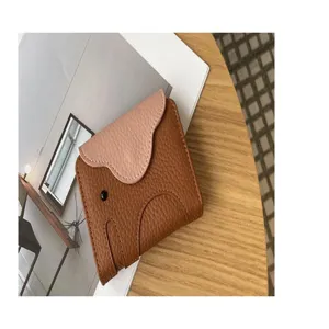 Close-up detail of genuine leather cute elephant card wallet with pink flap and card slots.
