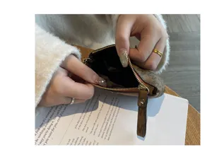 Close-up detail of women's mini coin purse with cute zipper and letter print design.