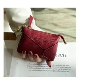 Genuine leather red coin purse detail showing soft cowhide texture, zipper and key ring.