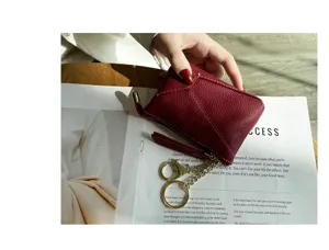 Close-up detail of genuine leather coin purse with soft cowhide, zipper, and key chain.