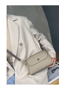 Detailed view of a fashionable genuine leather crossbody bag with chic contrast strap for daily wear.
