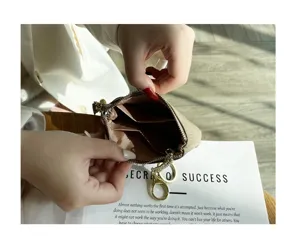 Compact genuine leather coin purse with zipper closure, card slots and metal key ring.