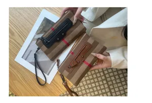 Λεπτομερής άποψη γυναικείας τσάντας clutch από καμβά με δερμάτινη λεπτομέρεια και πορτοφολι.