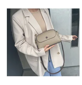 Detailed view of the genuine leather crossbody bag with flap and magnetic button.