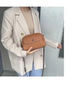 Close-up of a stylish brown leather crossbody bag showcasing pebble texture and fine stitching.