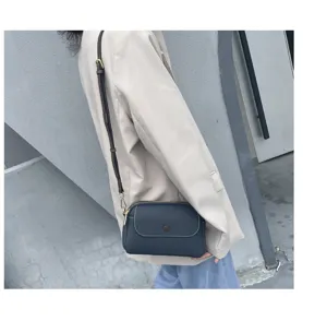 Dark blue leather crossbody bag, stylish shoulder bag with adjustable strap and metal hardware.
