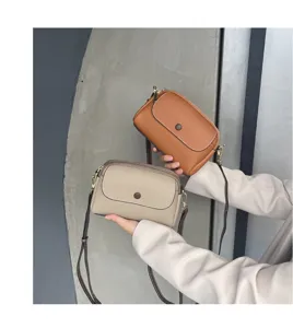 Detailed close-up showing dual leather cross-body shoulder bags in khaki and brown tones.