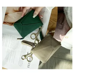 Detail view of genuine leather coin purse with zipper closure, soft cowhide texture and key chain.