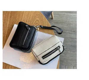 Close-up of mini genuine leather double zipper coin purses with wrist straps in dual colors.