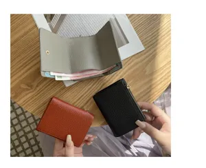 Detailed view of mini tri-fold leather wallet in multiple colors with coin pocket and card slots.