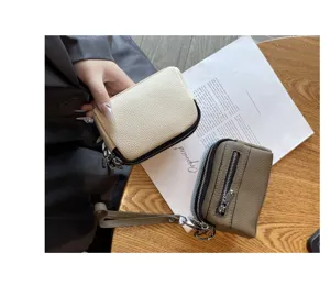 Compact genuine leather mini coin purse featuring dual zippers, wrist strap, and portable daily design.