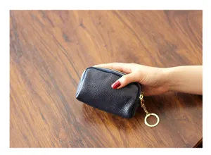 Detailansicht der dunkelblauen Mini Leder Geldbörse mit drei Reißverschlüssen und Ring.