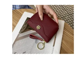 Wine red leather coin purse detail, compact wallet with zipper, wrist strap, and keychain ring.