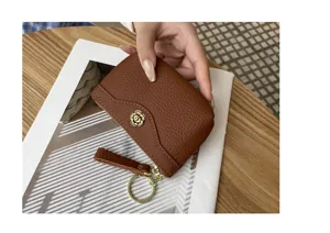 Genuine leather coin purse for women, brown cowhide card holder with wrist strap and flower clasp.