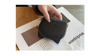 Compact black genuine leather card holder with cute ear design and smooth metal zipper detail.