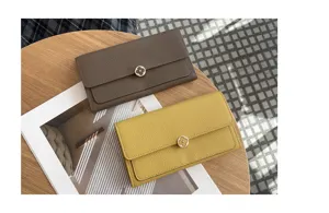 Closeup of women's genuine leather long wallet with soft cowhide and stylish floral metal clasp.