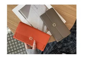 Detail view of genuine leather long wallet with clover metal snap closure in orange and taupe.