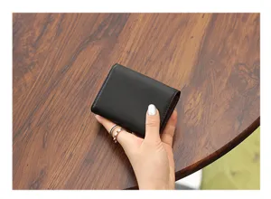 Tarjetero minimalista de cuero negro para mujer, mini cartera compacta con múltiples ranuras.