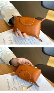 Mini brown leather coin purse with cute keychain charm and secure snap closure detail.