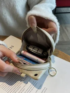 Compact genuine leather coin purse for women, portable mini cowhide key pouch with zipper.
