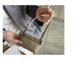 Detail view of mini leather coin purse with zipper closure and wrist strap hanging display.