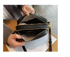 Genuine leather women camera bag interior detail showing large capacity double zip compartments.