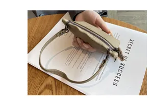Mini leather coin purse detail showing soft material, secure zipper closure, and handy wrist strap.
