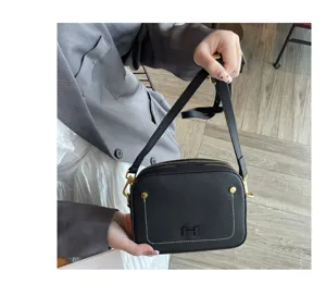 Detailed view of black genuine leather camera bag featuring contrast stitching and hardware.