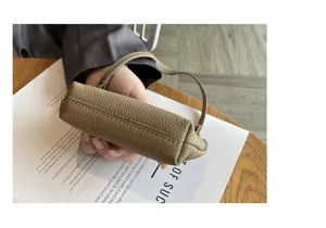 Genuine leather mini coin purse featuring secure zipper closure and short handle detail.