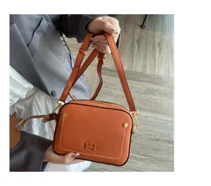 Stylish orange leather crossbody shoulder bag for women, premium camera bag with chic design.