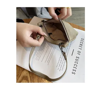 Minimalist genuine leather coin purse with zipper closure and wrist strap for women.