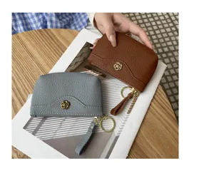 Genuine leather coin purse with chic floral metal decor, zipper closure, and key ring.