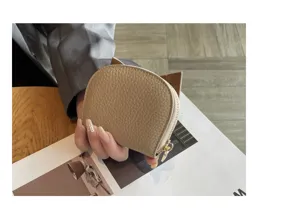 Detailed view of a compact genuine leather card holder with zip closure in beige. Perfect size.