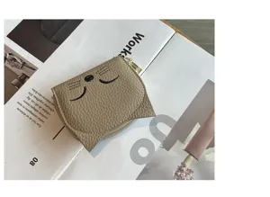 Minimalist genuine leather card holder with cute cat embroidery and zipper, compact and slim design.