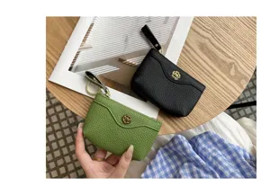 Close-up detail of genuine leather coin purse with chic metal flower clasp and wrist strap.