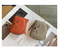 Close-up detail of cute cat-shaped leather card wallet with fine embroidery and zipper closure.