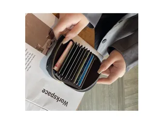 Detailed view of black leather accordion card wallet interior with multiple slots and zipper.