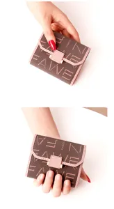 Compact brown monogram card wallet with pink trim and secure magnetic buckle closure.