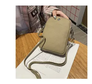 Genuine leather mini phone bag detail shot, compact crossbody pouch with fine shoulder strap.